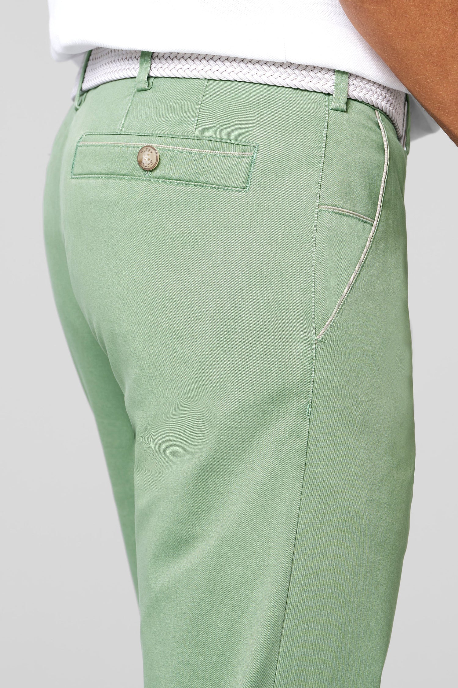 Green pants with a button on a light gray background