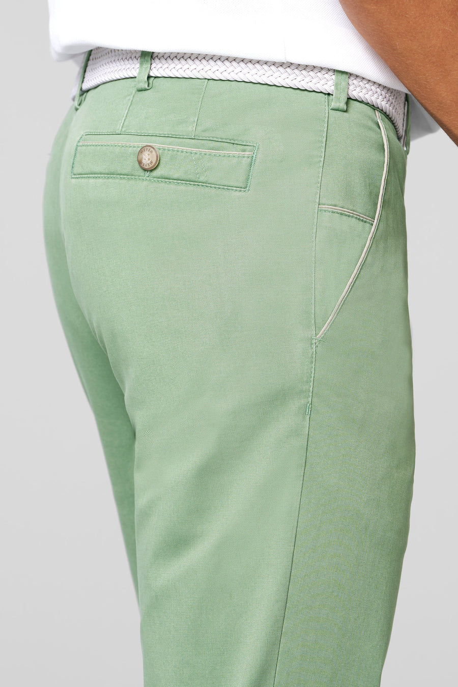 Green pants with a button on a light gray background